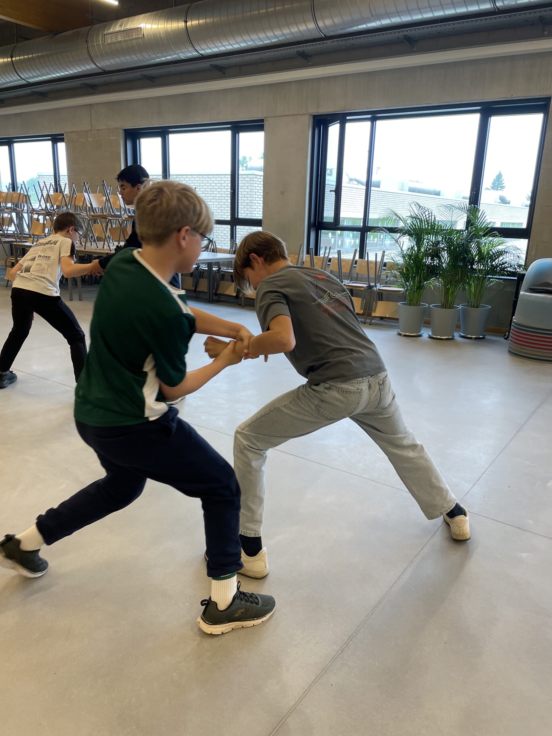 jongens in actie tijdens weerbaarheid en zelfverdediging voor tieners